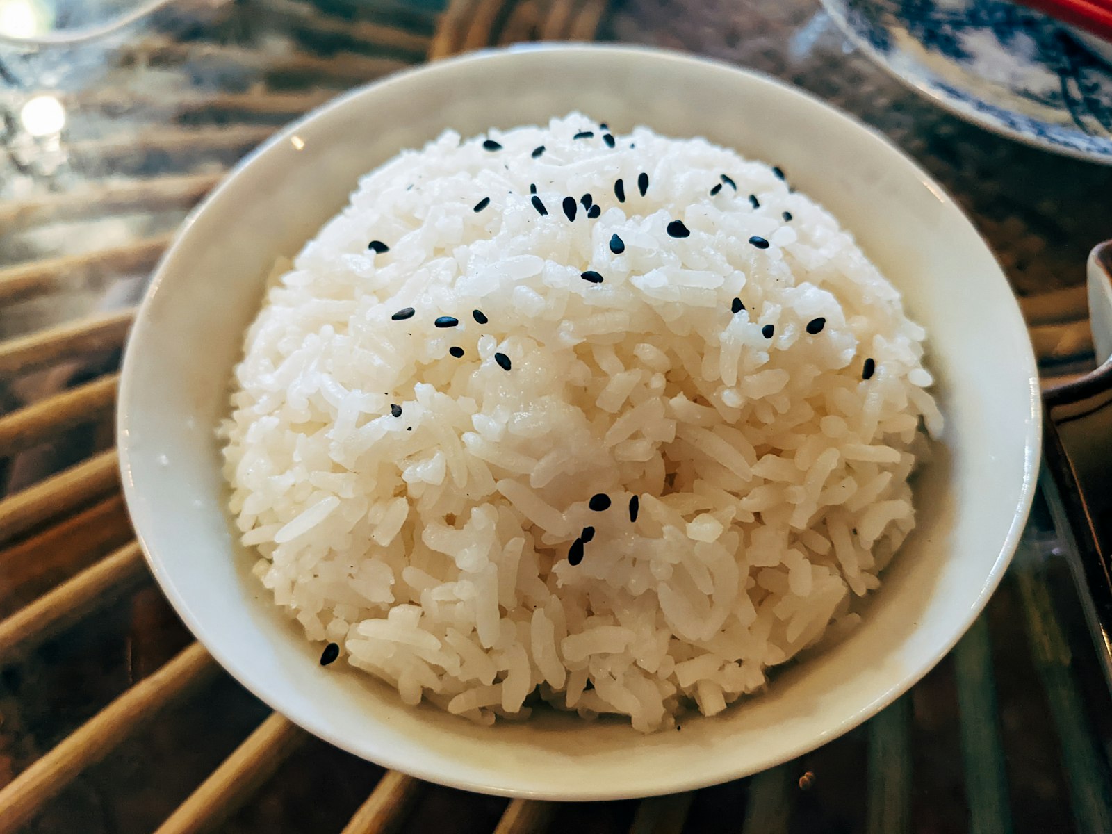 A bowl of white rice topped with black sesame seeds