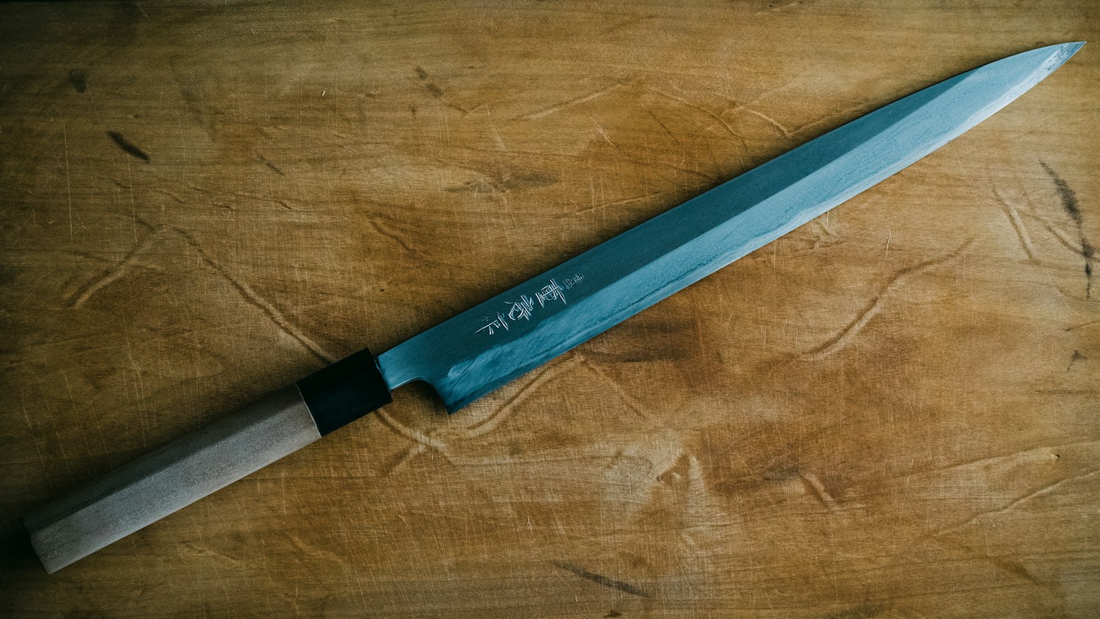 A Japanese knife resting on a wooden board